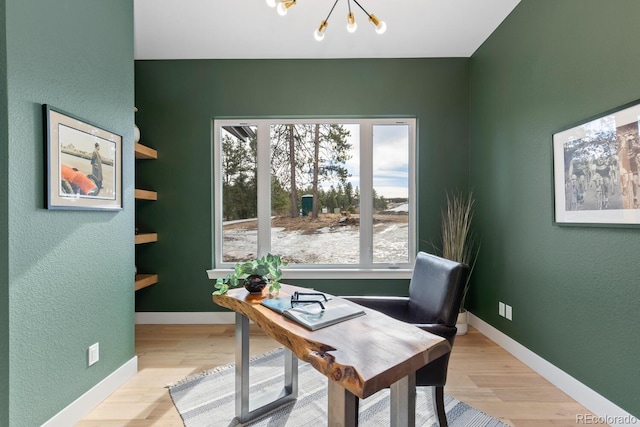 office with an inviting chandelier and light hardwood / wood-style floors