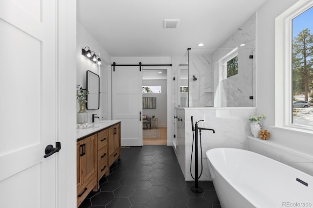 bathroom featuring independent shower and bath, vanity, tile patterned flooring, and a wealth of natural light