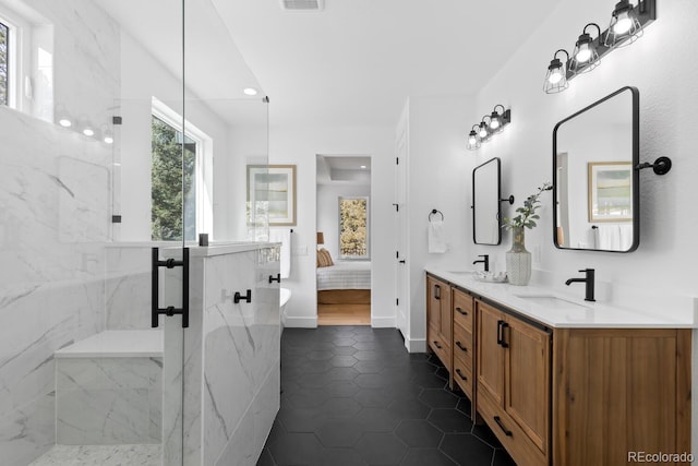 bathroom with tile patterned flooring, vanity, and tiled shower