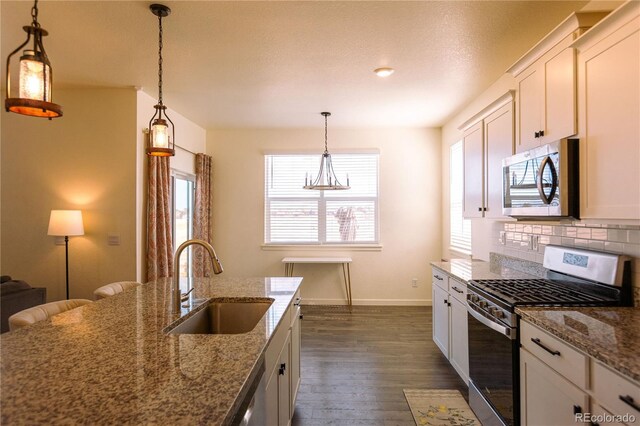 236 Racer St, Bennett, CO 80102 - kitchen featuring stone counters, tasteful backsplash, dark wood finished floors, stainless steel appliances, and a sink