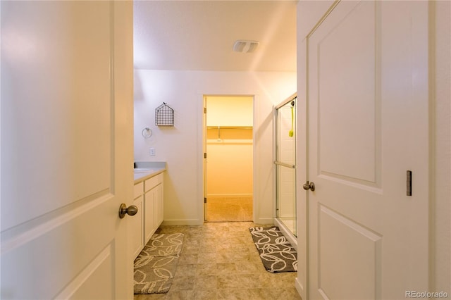 236 Racer St, Bennett, CO 80102 - full bath featuring a shower stall, vanity, a spacious closet, visible vents, and baseboards