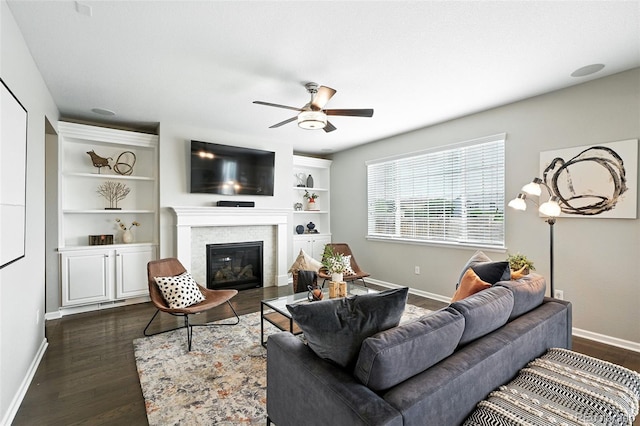 12554 Hudson Ct, Thornton, CO 80241 - living room with ceiling fan, dark wood-style floors, a glass covered fireplace, and built in features