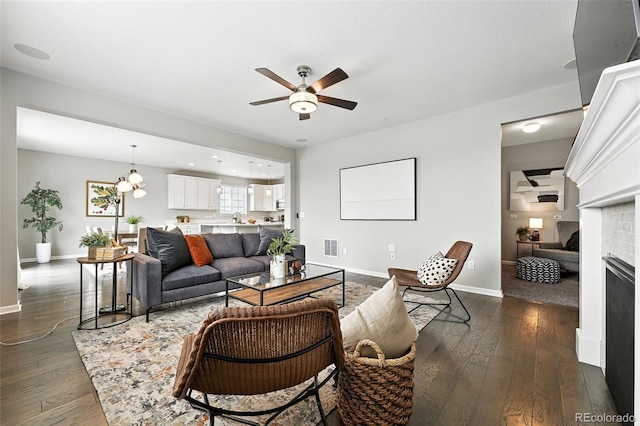 12554 Hudson Ct, Thornton, CO 80241 - living area with a ceiling fan, a fireplace, and dark wood-style flooring