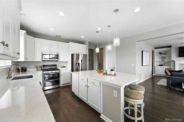 12554 Hudson Ct, Thornton, CO 80241 - kitchen featuring appliances with stainless steel finishes, open floor plan, dark wood-type flooring, recessed lighting, and white cabinetry