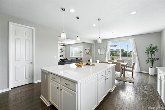 12554 Hudson Ct, Thornton, CO 80241 - kitchen featuring dark wood-type flooring, a center island, recessed lighting, white cabinets, and light countertops