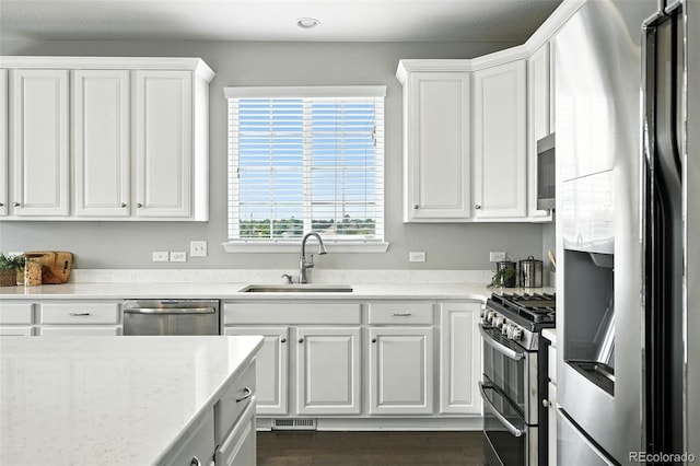 12554 Hudson Ct, Thornton, CO 80241 - kitchen with stainless steel appliances, white cabinets, light stone countertops, dark wood-style floors, and recessed lighting