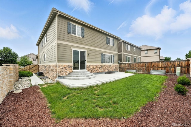 12554 Hudson Ct, Thornton, CO 80241 - back of house featuring stone siding, a fenced backyard, a patio, and entry steps