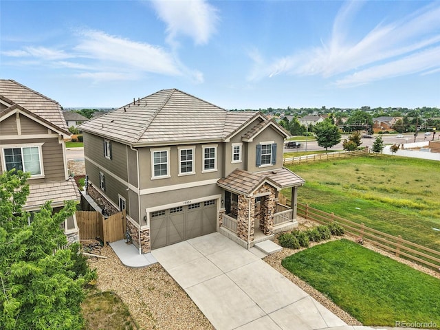12554 Hudson Ct, Thornton, CO 80241 - view of front facade featuring stone siding, a garage, driveway, stucco siding, and a porch