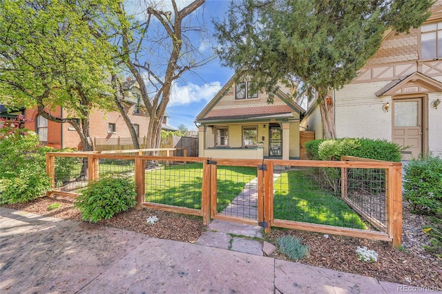 bungalow-style house with a fenced front yard, brick siding, a porch, a front yard, and a gate
