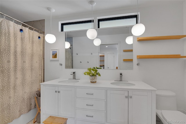 bathroom featuring a sink, toilet, and double vanity