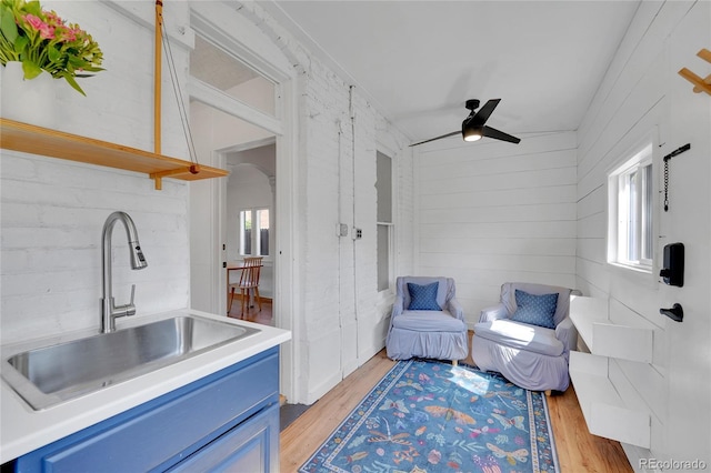 living area featuring a ceiling fan, light wood finished floors, and lofted ceiling