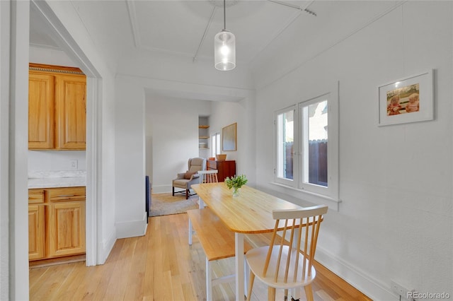 dining space featuring baseboards and light wood finished floors