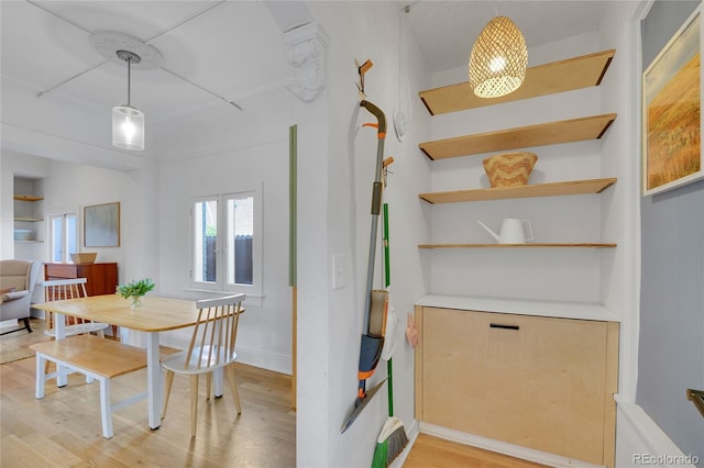 dining space featuring baseboards and light wood finished floors