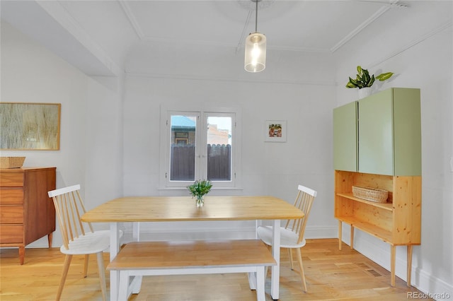 dining area with ornamental molding and light wood-type flooring