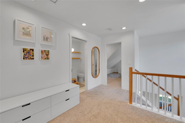 hallway featuring recessed lighting, light colored carpet, and an upstairs landing