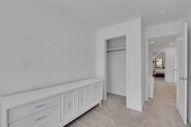 unfurnished bedroom featuring recessed lighting, baseboards, light colored carpet, and a closet