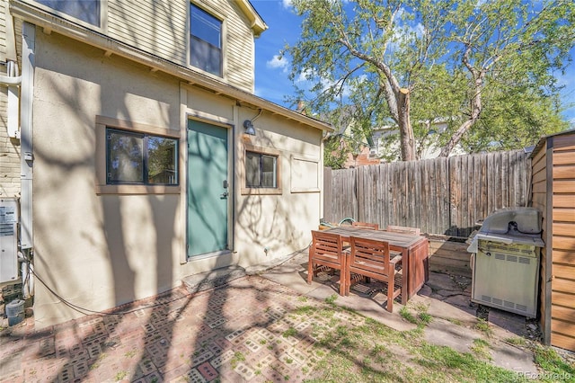 exterior space featuring a fenced backyard, outdoor dining space, and a grill