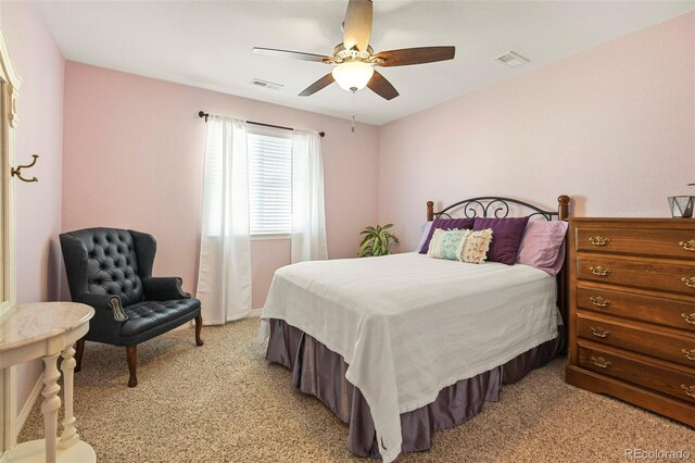 bedroom featuring visible vents, a ceiling fan, and light carpet