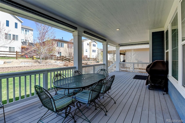 wooden terrace with a yard, a residential view, and outdoor dining area