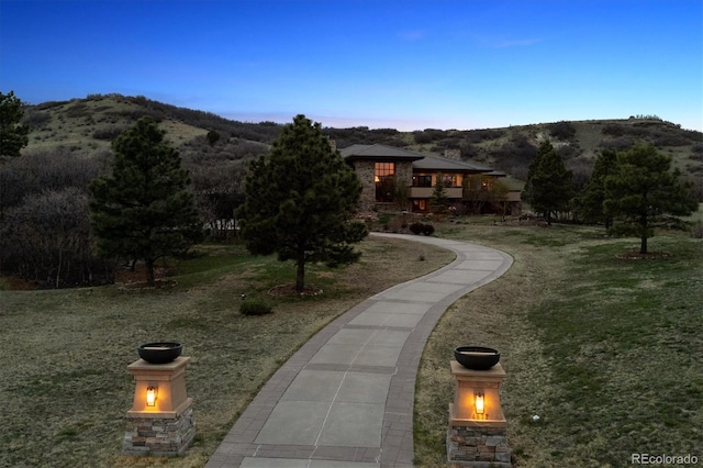 view of property's community featuring a lawn and a mountain view