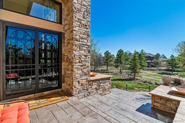 view of exterior entry featuring a patio area and french doors