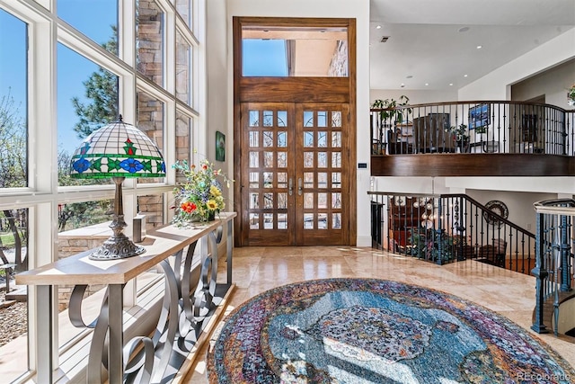 entryway featuring marble finish floor, a high ceiling, french doors, and recessed lighting