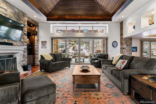 living area featuring wood finished floors, a tray ceiling, a fireplace, wooden ceiling, and recessed lighting