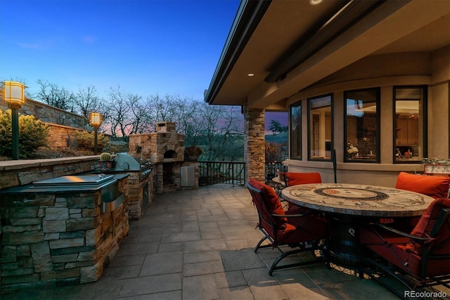 view of patio featuring an outdoor kitchen, outdoor dining area, and area for grilling