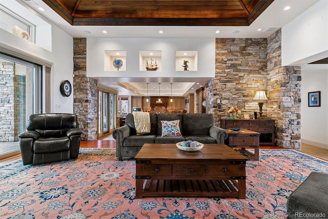 living area with wood finished floors, a tray ceiling, and recessed lighting