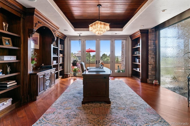 office space featuring wood finished floors, a tray ceiling, a chandelier, and wooden ceiling
