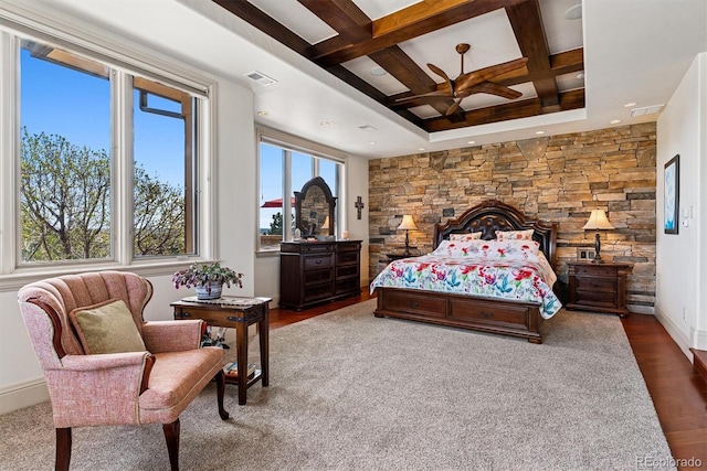 bedroom featuring coffered ceiling, wood finished floors, visible vents, beam ceiling, and baseboards