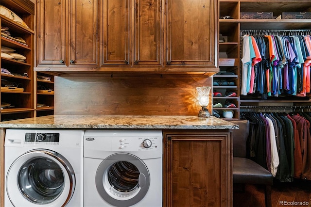 laundry room featuring washing machine and clothes dryer and cabinet space