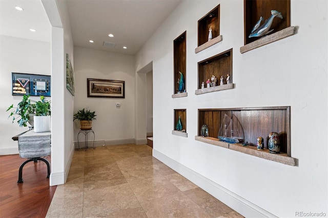 corridor featuring baseboards, visible vents, and recessed lighting