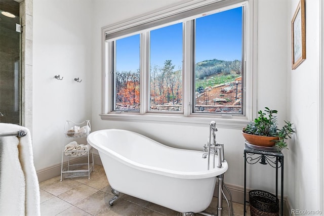 bathroom featuring a soaking tub, tile patterned floors, and baseboards