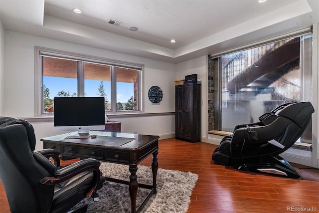 office space featuring recessed lighting, a raised ceiling, and wood finished floors