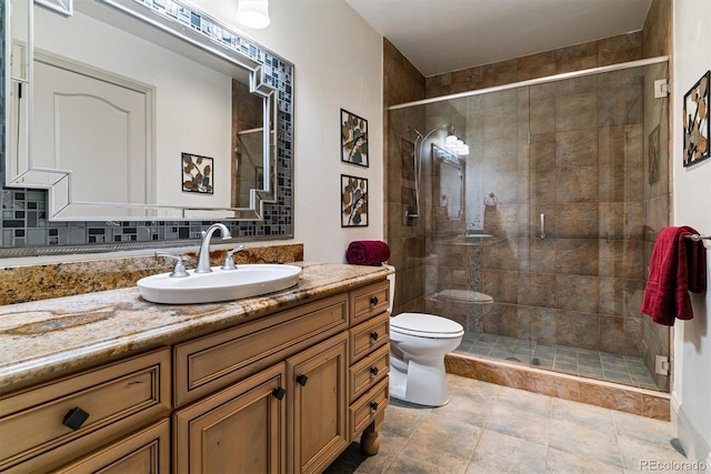 full bathroom with vanity, a shower stall, and toilet