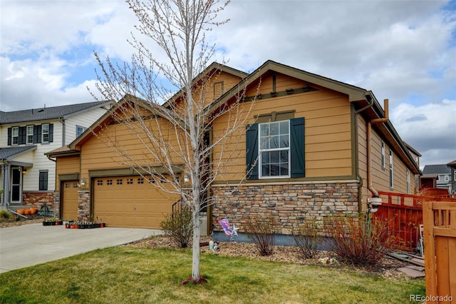 craftsman inspired home with fence, an attached garage, concrete driveway, stone siding, and a front lawn