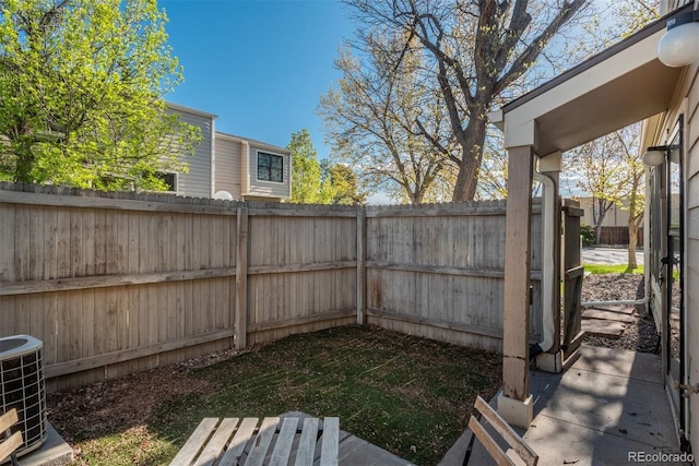 view of yard featuring fence and central AC unit