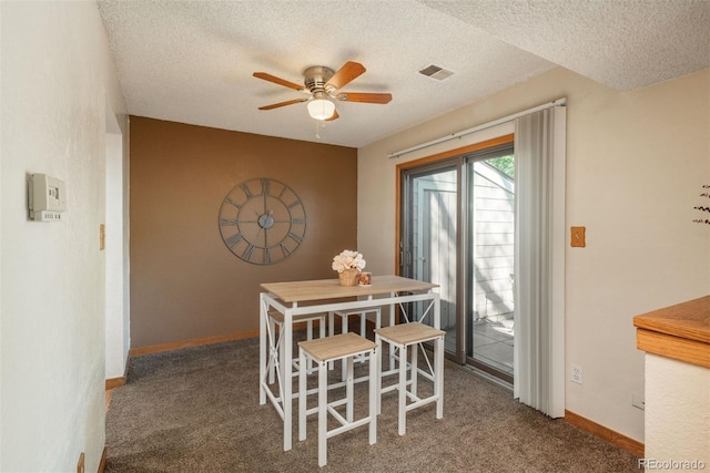 carpeted dining space with a ceiling fan, a textured ceiling, and baseboards