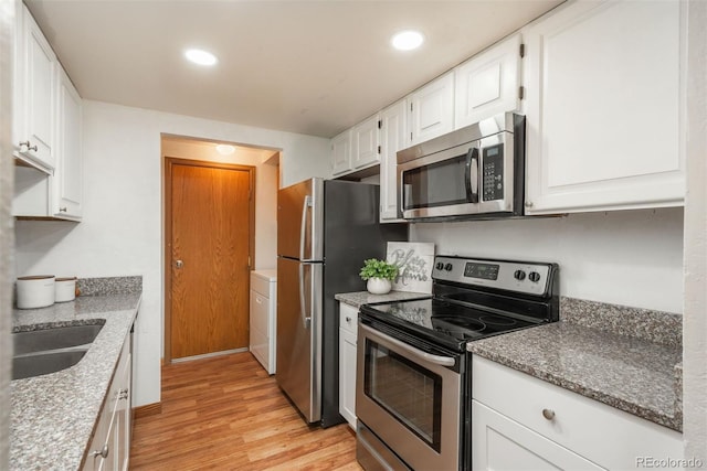 kitchen featuring stainless steel appliances, light wood finished floors, white cabinetry, a sink, and recessed lighting
