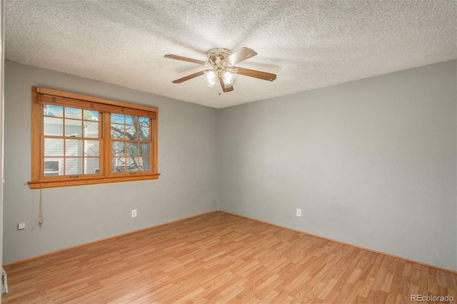 unfurnished room with wood finished floors, a ceiling fan, and a textured ceiling