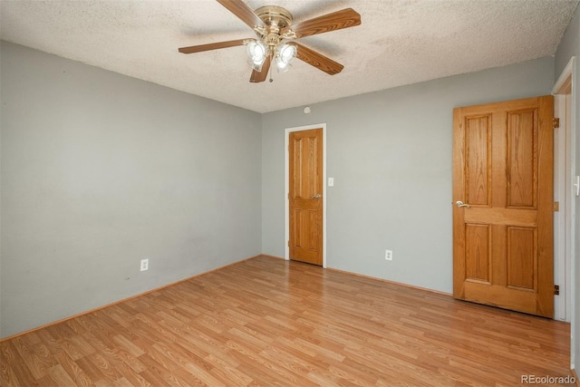 spare room featuring light wood-style floors, a textured ceiling, and ceiling fan