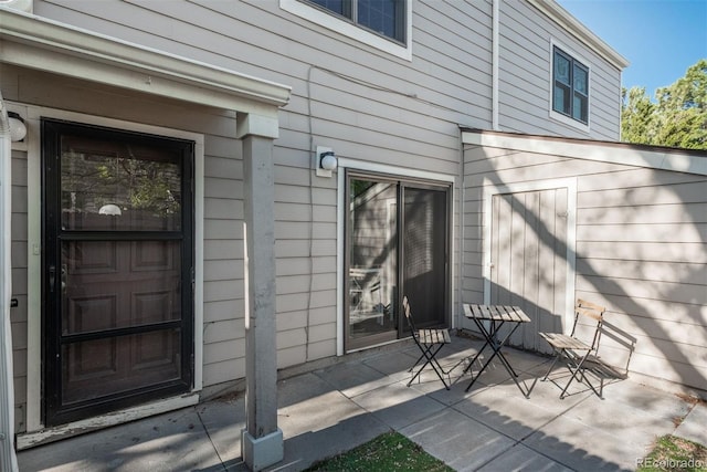 view of exterior entry with a patio