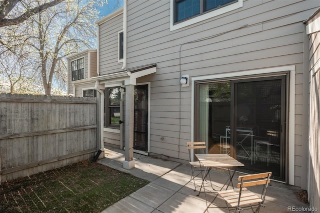 rear view of property featuring fence and a patio area