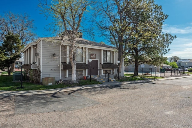 view of front of home featuring fence and cooling unit