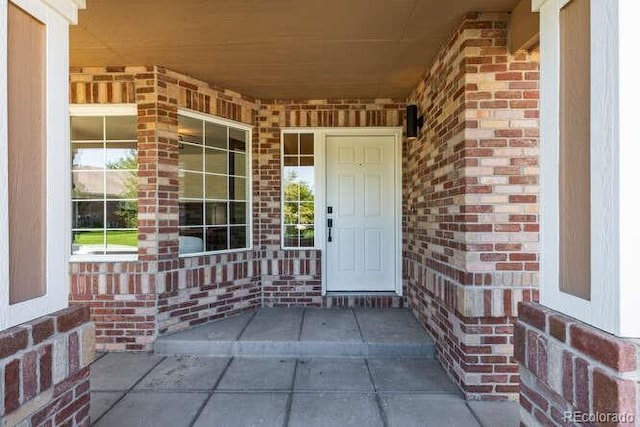 9561 Silver Hill Cir, Lone Tree, CO 80124 - doorway to property with brick siding and covered porch
