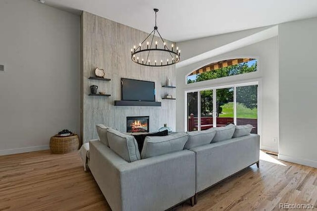 9561 Silver Hill Cir, Lone Tree, CO 80124 - living area with a fireplace, wood finished floors, a chandelier, and a high ceiling