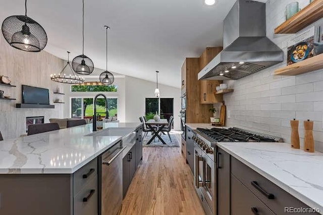 9561 Silver Hill Cir, Lone Tree, CO 80124 - kitchen featuring wall chimney exhaust hood, appliances with stainless steel finishes, vaulted ceiling, tasteful backsplash, and light wood finished floors