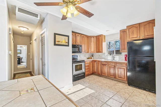 kitchen with sink, ceiling fan, backsplash, tile counters, and black appliances