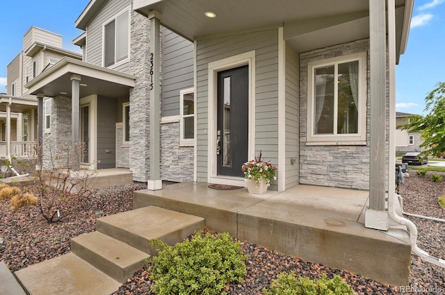 23615 E 5th Pl, Aurora, CO 80018 - view of exterior entry with stone siding and a porch